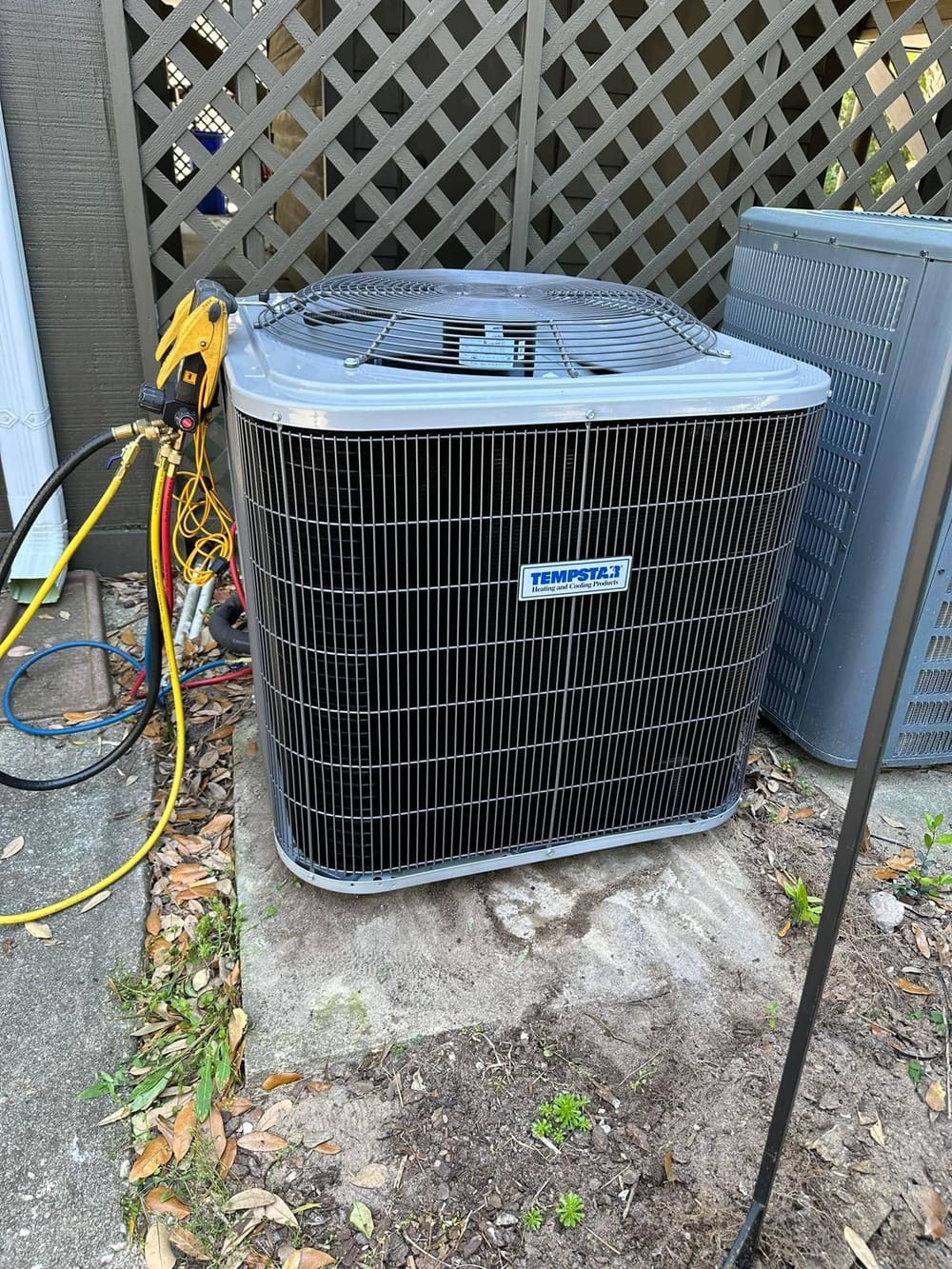New Tempstar outdoor condenser with gauge hoses connected on a pad