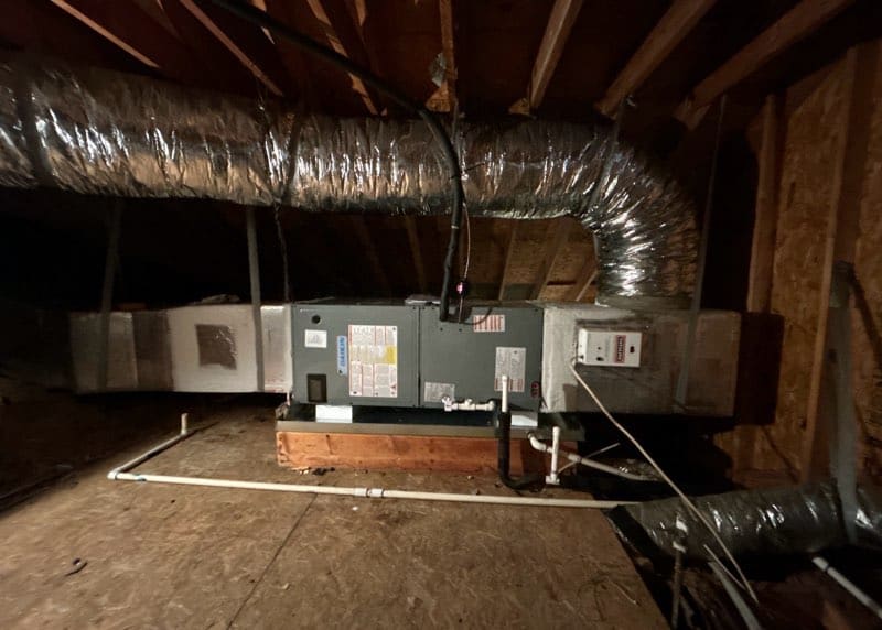 Air handler set on a wood platform in an attic with insulated duct