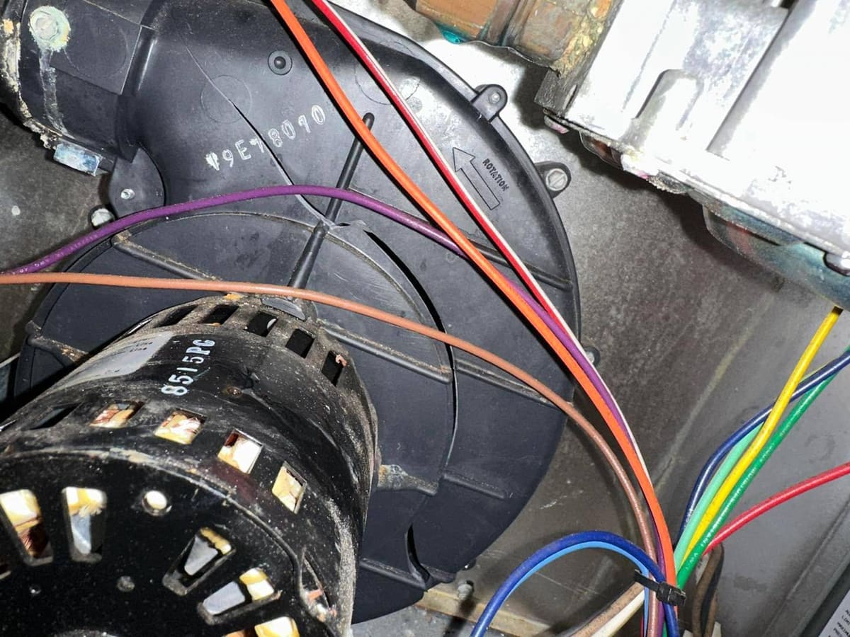 Blower motor and wiring inside a furnace during a repair