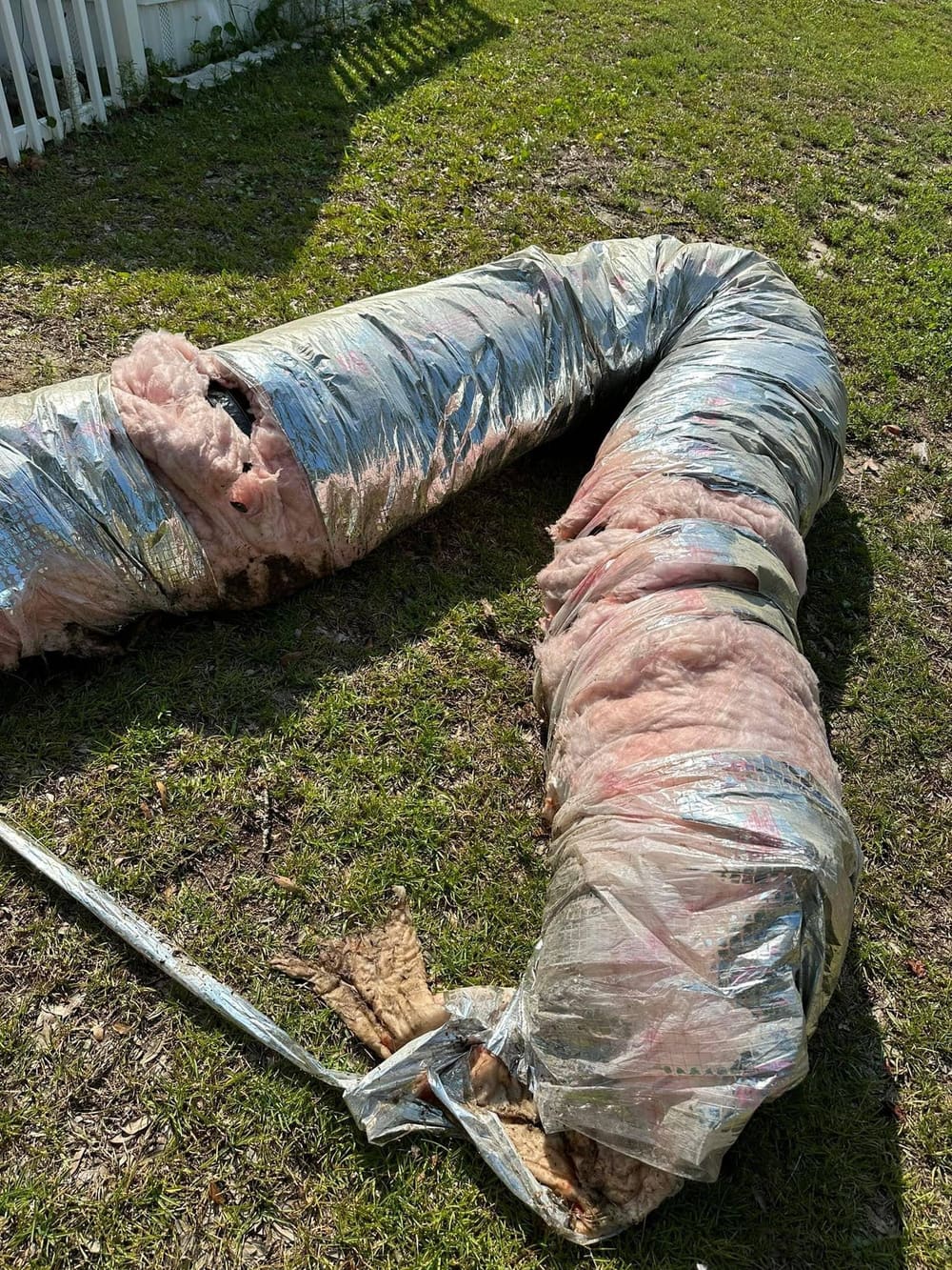 Old flex duct pulled out of a house and laid on the lawn