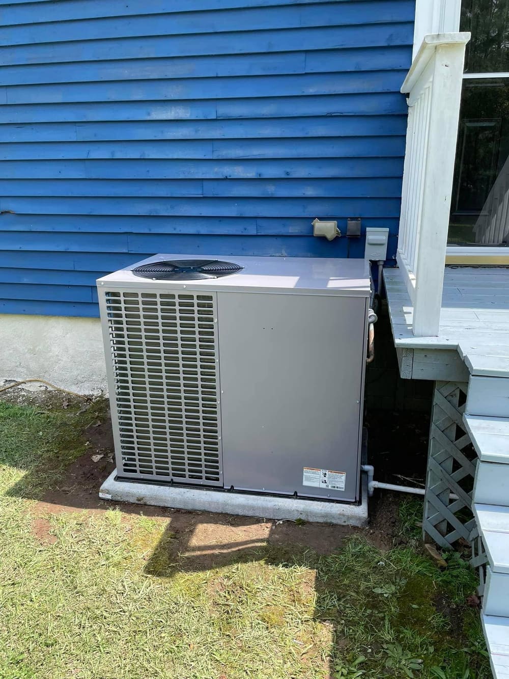 Package unit beside a blue-sided house