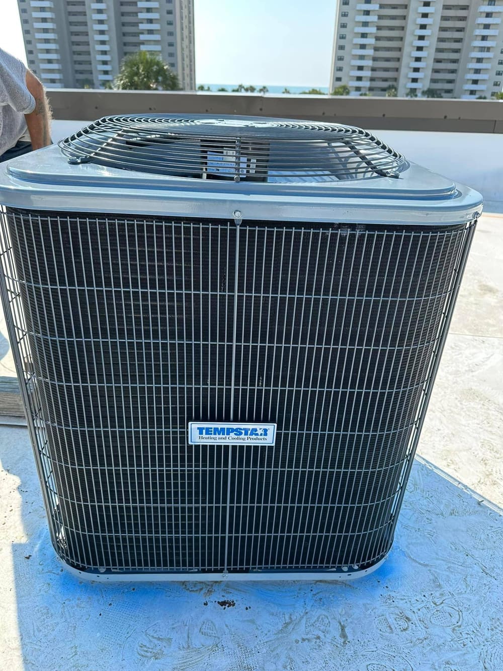 A new Tempstar outdoor condenser on a roof with the coast skyline behind it