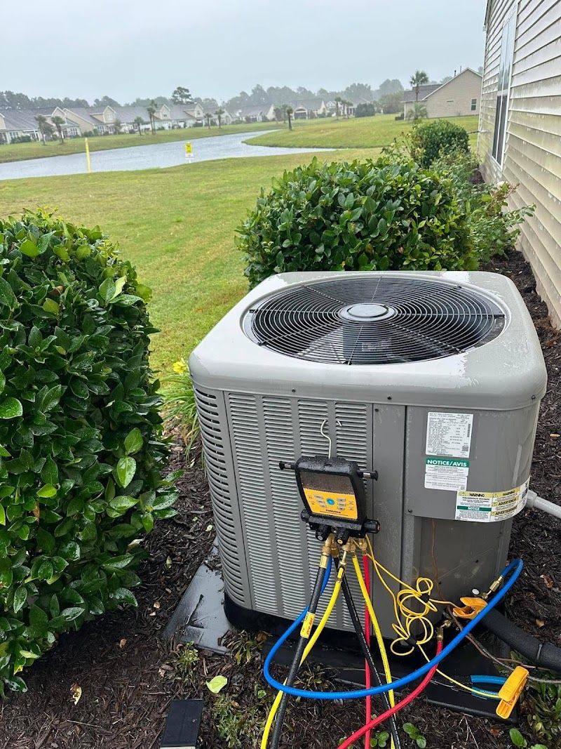 AC condenser with refrigerant gauges serviced by Arctic Air Conditioning